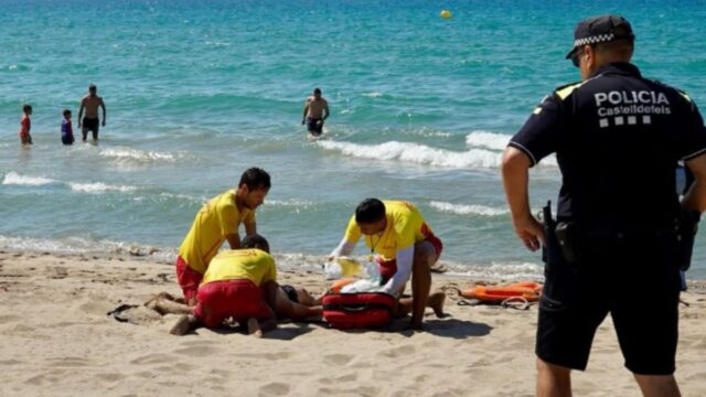 Imatge del moment del rescat de l'home inconscient a la platja de Lluminetes (Policia Local de Castelldefels)